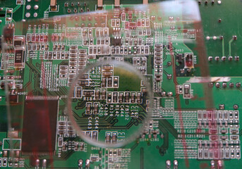 Surface mount components on electronic circuit under the magnifying glass.