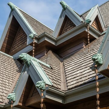 Roofline details with decorative animal gargoyles and copper gutters showcase a meticulously crafted architectural design.