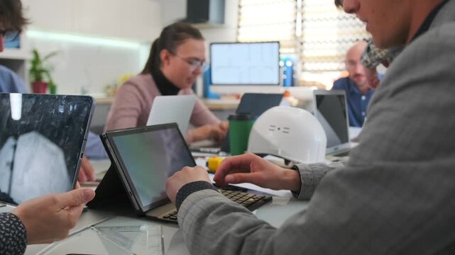 caucasian team uses digital tools, designers collaborate with tablets and sketches, diverse group of designers collaborating actively using digital devices and sketches during brainstorming session