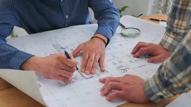 engineer reviews plan with contractor, engineer carefully reviews blueprint while collaborating with contractor nearby, engineer thoroughly evaluates design plans and works closely with contractor