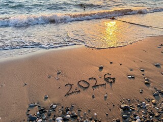 2026 new year concept. 2026 Written in Sand on a Beach with Golden Sunset Reflection