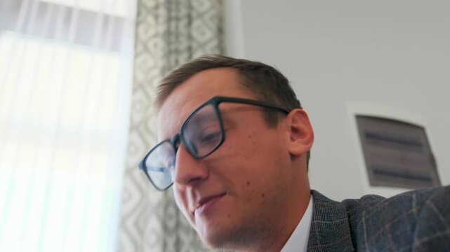 white man studying paper details, professional man in suit reviewing documents thoughtfully in natural lighting, focused white man in suit carefully analyzing papers in softly lit office environment