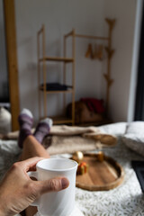woman in cozy bedroom with a hot drink