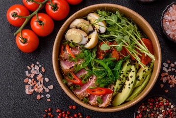Seared tuna tataki in a bowl with sesame seeds, rice, and vegetables. Tuna tataki