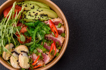 Seared tuna tataki in a bowl with sesame seeds, rice, and vegetables. Tuna tataki