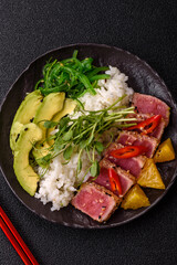 Seared tuna tataki in a bowl with sesame seeds, rice, and vegetables. Tuna tataki