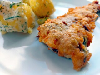 Smeared Fish Served With Seasoned Potatoes on a White Plate