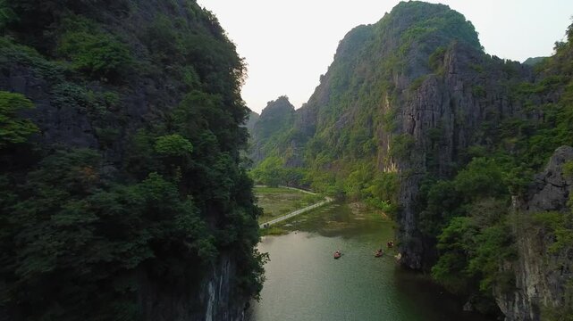 Flying in Tam Coc - Vietnam. With the river full of kayaks and the green mountains around.