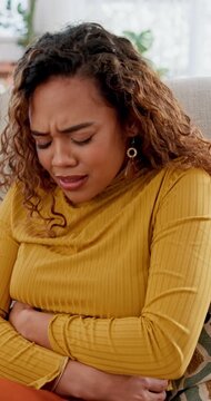 Stomach, ache and pain with woman on sofa for ibs symptoms, digestive issue and bloating. Gastrointestinal cramps, ulcer and indigestion with female person in living room of home for appendicitis