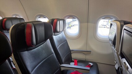 Comfortable airplane cabin interior with empty passenger seats and window views