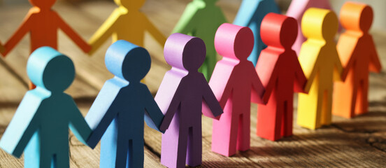Colorful paper cut-out people holding hands representing diversity and teamwork symbolizing unity and cooperation