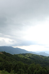 Fototapeta premium Picturesque mountain slopes under a cloudy sky.The mountains convey the natural beauty and vast expanses of the Carpathian landscape, ideal for promoting travel, tourism, ecology, and landscape design