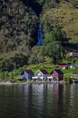 Houses at the bottom of a waterfall in Bakka, Norway