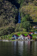 Houses at the bottom of a waterfall in Bakka, Norway
