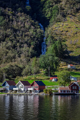 Houses at the bottom of a waterfall in Bakka, Norway