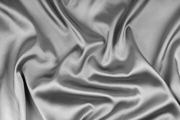 Crumpled, wrinkled gray colored glossy silk satin texture. Shiny smooth fabric with soft folds, cloth with wave drapery. Elegant and rich background, wallpaper, backdrop. Flat lay, top view