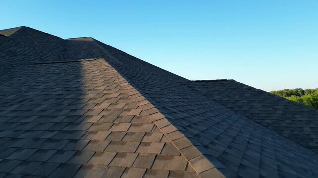 Aerial Drone Footage Showcases Residential Roof Shingles Under Clear Blue Sky
