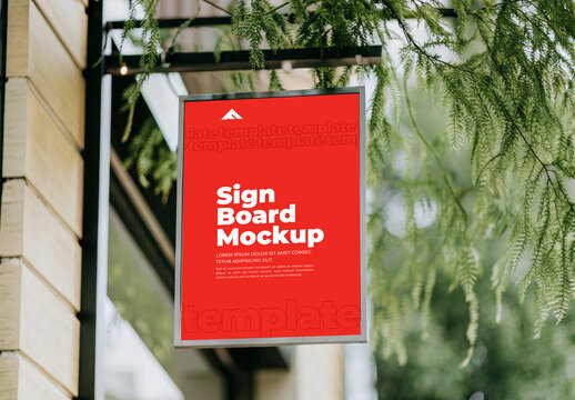Vertical Sign Board Mockup on Building Wall Surrounded by Green Plants and Leaves