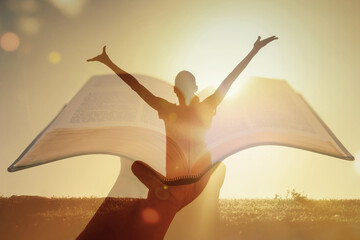 Joyful woman raises hands to worship and praise God. Hand holding up bible  