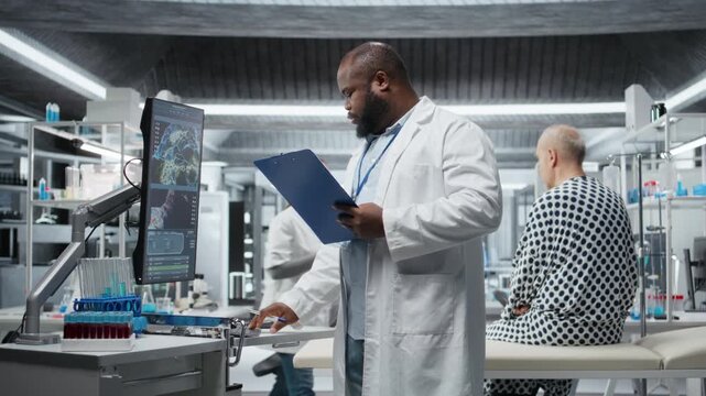 Black medic monitoring patient vitals and DNA molecules on monitor, conducting a laboratory study and testing new treatment. Male doctor works on a medical breakthrough. Camera A.