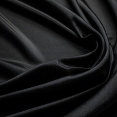 Fototapeta premium Close-up of luxuriously draped black satin fabric. The folds and shadows create a rich texture and depth, evoking elegance and sophistication