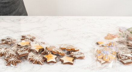 Fototapeta premium Person Packaging Decorated Christmas Cookies in Festive Holiday Assortment