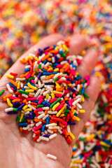 Obraz premium Hand Holding Colorful Sprinkles Close Up