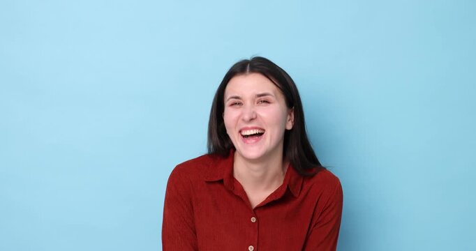 Beautiful woman laughing on light blue background