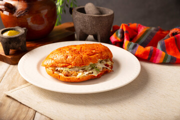 Pambazo. Mexican sandwich marinated in red sauce and roasted on a comal traditionally stuffed with potatoes and chorizo, a classic of Mexico City street food.