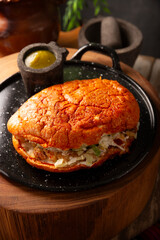 Pambazo. Mexican sandwich marinated in red sauce and roasted on a comal traditionally stuffed with potatoes and chorizo, a classic of Mexico City street food.