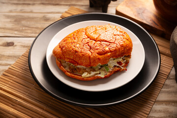 Pambazo. Mexican sandwich marinated in red sauce and roasted on a comal traditionally stuffed with potatoes and chorizo, a classic of Mexico City street food.