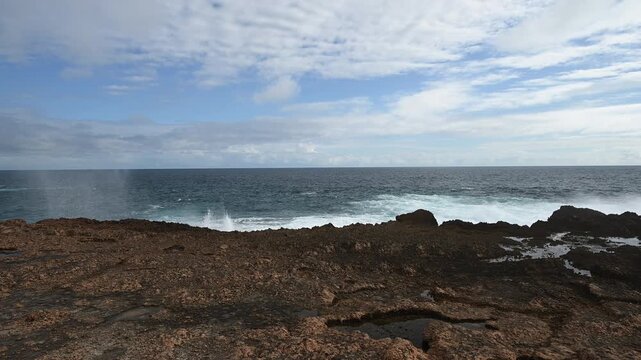 rugged landscape of the rocky cliffs at Quobba Blow Holes, Macleod, Western Australia, along the coastline of the indian Ocean in West Australia with waves crushing ashore.