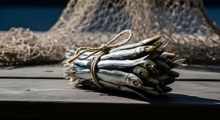 A bundle of dried fish tied with twine sitting on a wooden surface with a fishing net backdrop