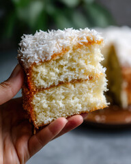hand holding fluffy brazilian coconut cake slice with moist texture
