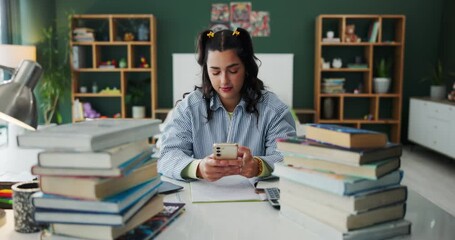 Homework, student and girl with smartphone, typing and contact with message, texting and social media. Apartment, person and woman with cellphone, digital app and books with research for assignment - Powered by Adobe