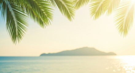 Fototapeta premium Lush green palm fronds hang over a calm turquoise sea and distant island bathed in soft sunlight