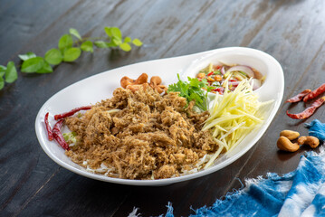 A plate of Yum Woon Sen, a spicy Thai salad made with glass noodles, pork, shrimp, vegetables, and a chili lime dressing.