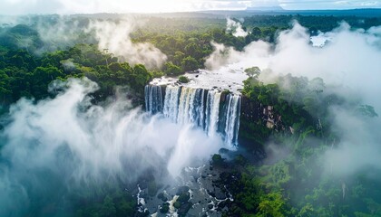 Fototapeta premium Aerial shot of a waterfall surrounded by fog, ultra-detailed water particles and lighting.