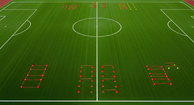 Football training equipment and agility drills set up on green soccer field for practice and fitness sessions