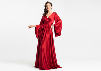Elegant woman in a flowing red satin evening gown posing gracefully on a white background.
