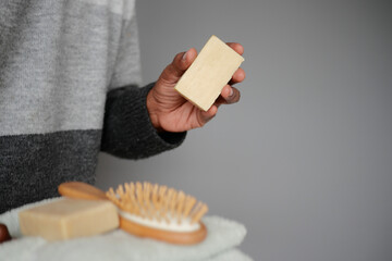 Person holding natural soap bar in bathroom setting