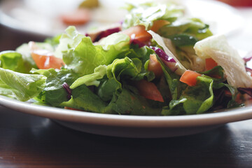 Fresh salad served on a white plate in a cozy setting