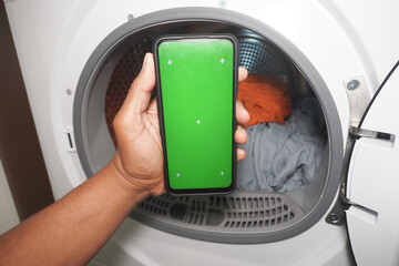 Dryer with smartphone showing a green screen