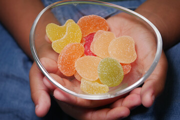 Colorful gummy candies in a child's hands