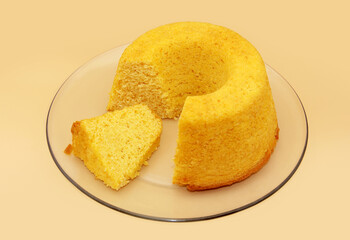 SOFT CORN FLOUR CAKE WITH CARROTS ON A TRANSPARENT PLATE ON AN ISOLATED BACKGROUND