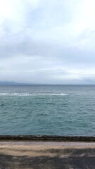 Fototapeta premium Calm Ocean Waters Meeting the Horizon Under a Cloudy Sky