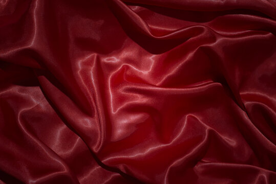 top view close-up of red satin fabric, smooth and luxurious, beautiful, classy, ​​wavy texture