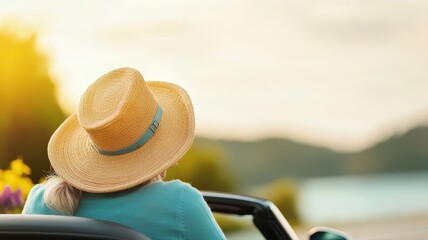 Scenic convertible road trip woman in straw hat enjoying freedom and leisure travel towards golden sunset over distant mountains and water