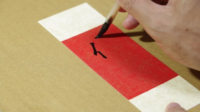 Writing Chinese Calligraphy Characters on Bookmark Card, Translation: "Generosity".