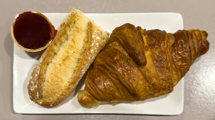 Breakfast: dish with delicious croissant, bread and jam